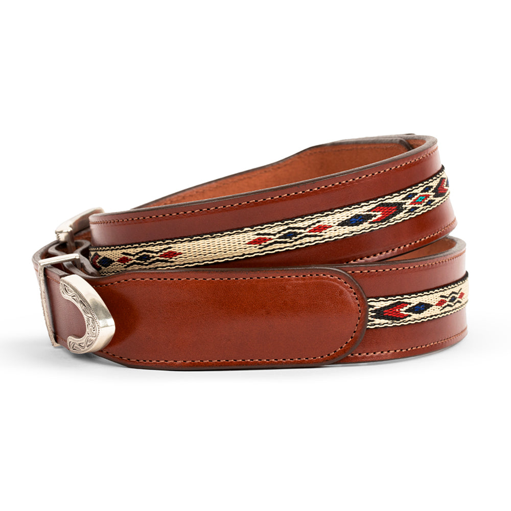 The Seneca Tapered by Hanks Belts features premium English Bridle vegetable-tanned leather in brown, a silver buckle, and a woven beige band with red, black, and blue geometric patterns—perfect for adding western flair.