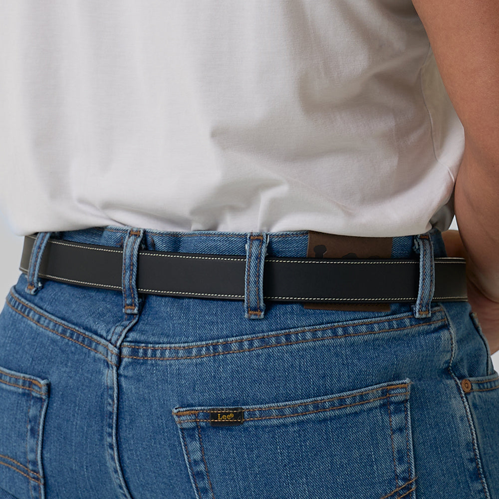 A person in blue jeans and a white t-shirt, shown from the back waist down, wears Hanks Belts' The Heritage Bison rugged leather belt threaded through their belt loops.