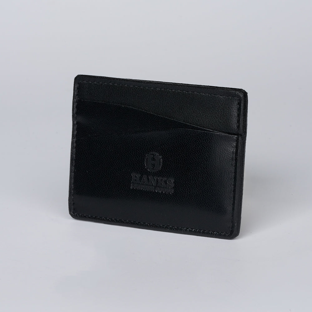 The Monroe Goatskin Card Holder by Hanks Belts is a black wallet with two visible card slots and "HANKS" embossed on the front, displayed upright against a plain light background.