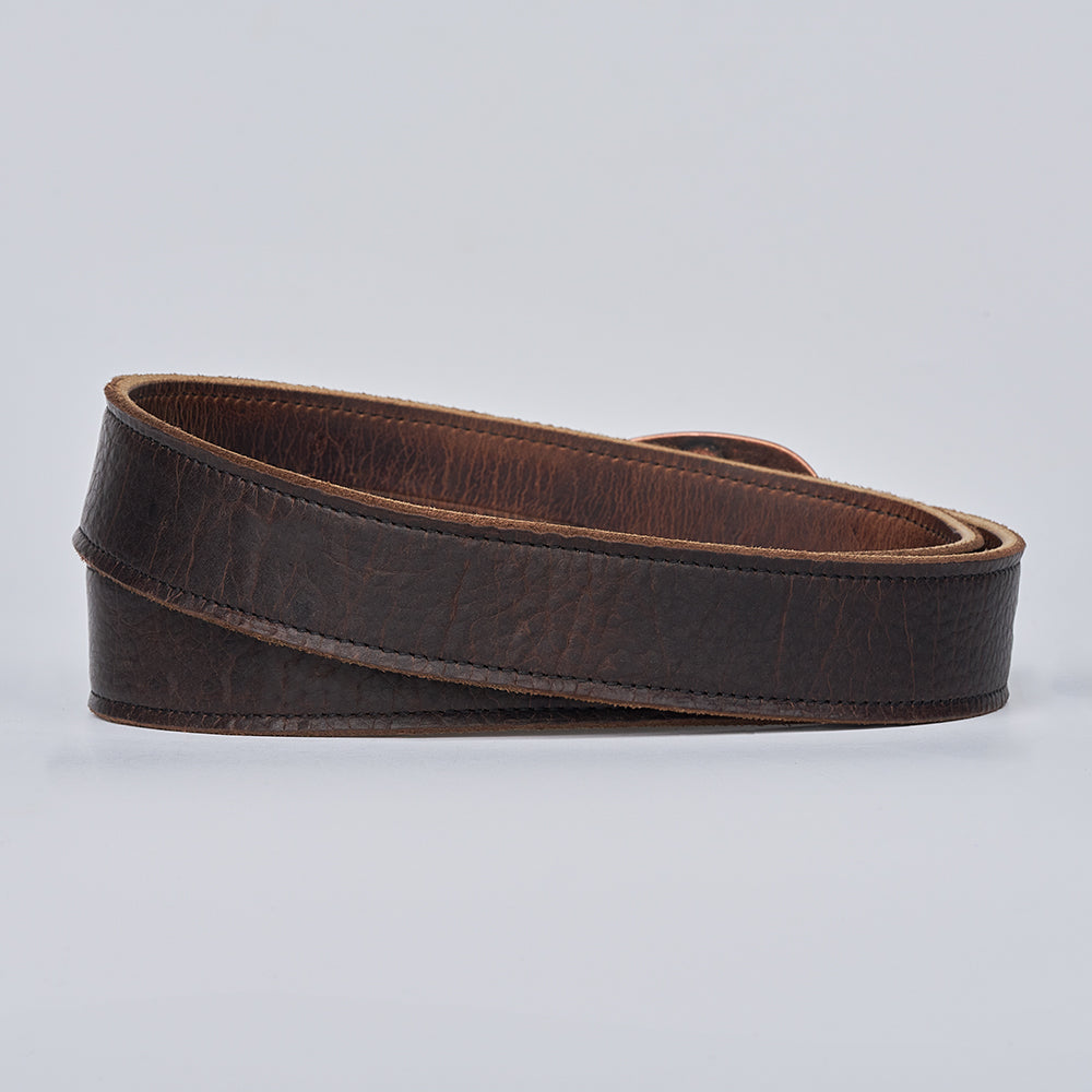 The Hanks Belts Ember - 1.25" is a rolled, dark brown leather belt with a textured surface, shown on a plain light background.
