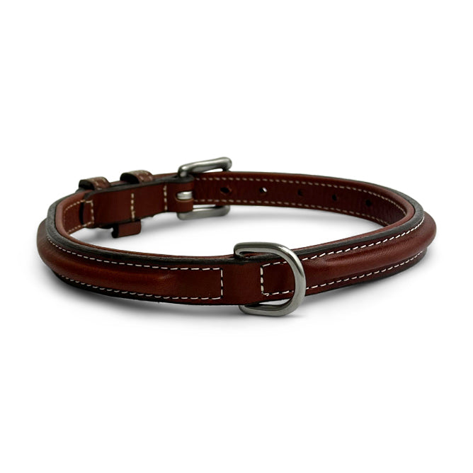 The Bentley Raised Collar by Hanks Belts is a brown, vegetable tanned leather dog collar with white stitching, stainless steel hardware, a metal buckle, and D-ring, shown on a white background.