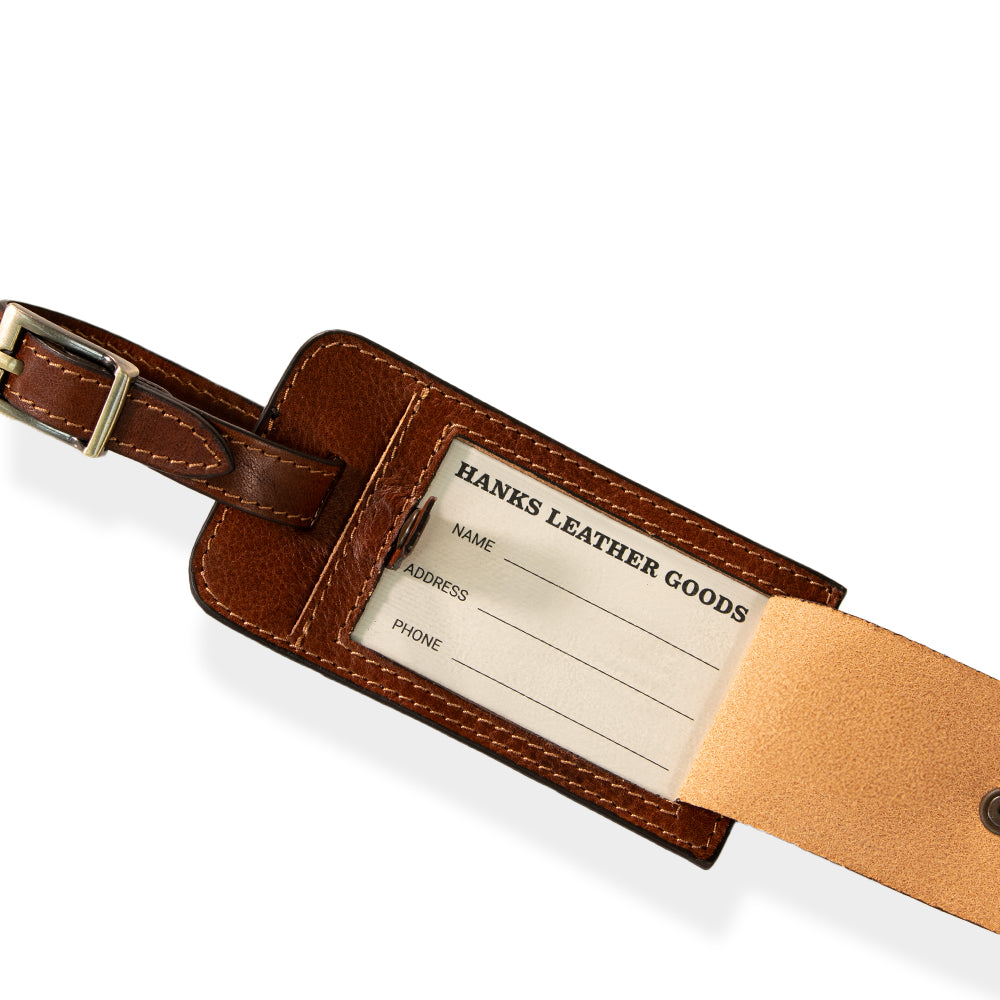 Discover the sophistication of the Luxury Luggage Tag by Hanks Belts, featuring a secure buckle strap and crafted from premium Italian full-grain leather. This elegant brown tag holds a card for your name, address, and phone number, seamlessly blending functionality with luxury.