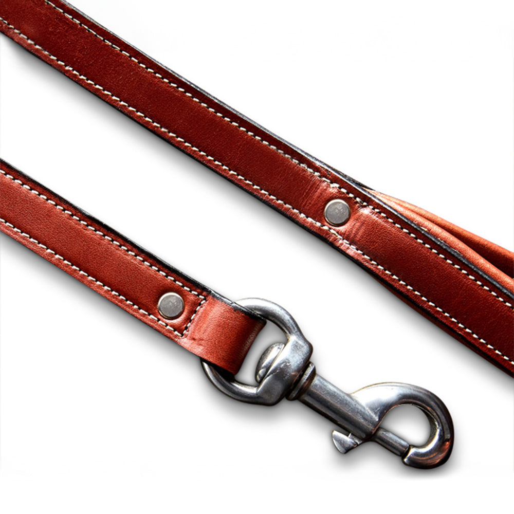 A close-up of the Hanks Belts Rover Standard Leash, featuring brown English Bridle leather with white stitching, metal rivets, a padded handle, and a silver clasp against a white background.