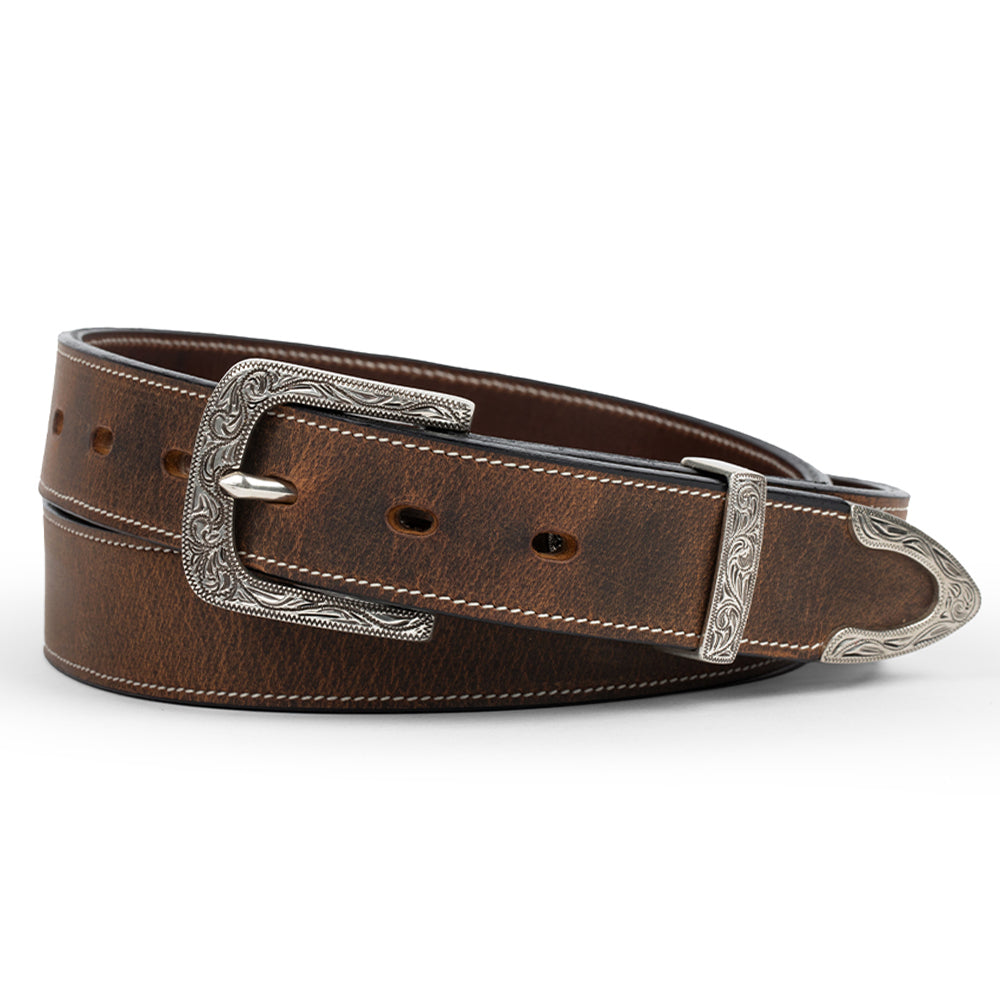 The Dakota Bison by Hanks Belts is a brown western belt made from premium North American bison leather, featuring an engraved silver floral buckle and tip, plus decorative stitching along the coiled edges.