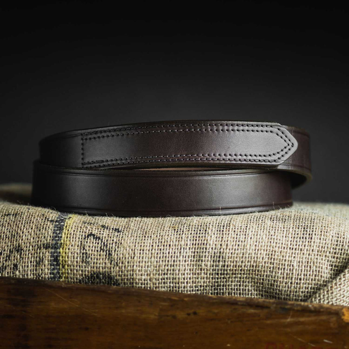 The Scratchless Mechanics by Hanks Belts is a genuine full grain leather belt with detailed stitching, displayed on textured burlap—a refined non-metallic accessory ideal for everyday style.