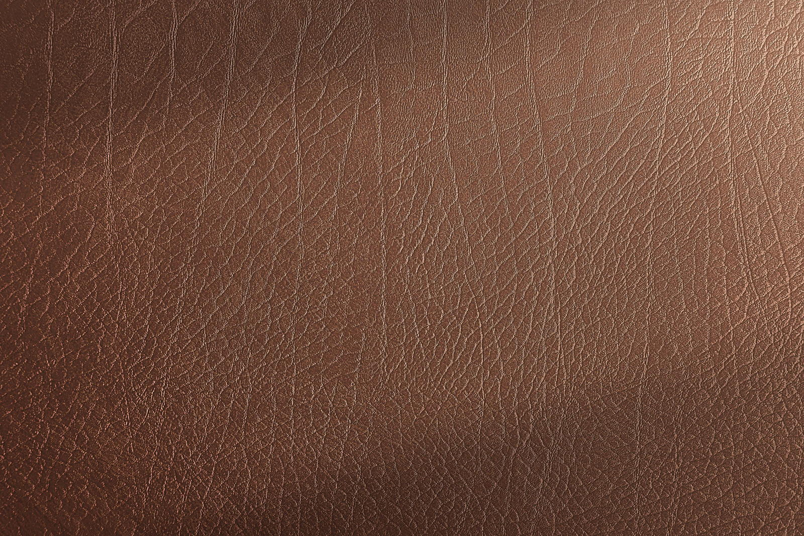 Close-up of brown leather texture, showing natural grain patterns and fine lines with a subtle sheen.