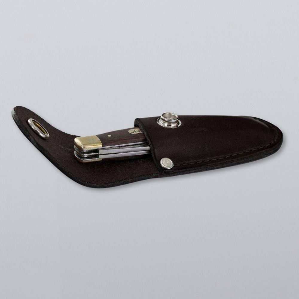The Hanks Belts Canyon Utility Sheath and Mag Case, featuring a black leather snap closure, holds a folding pocket knife with a black handle. Both are displayed on a plain light gray background.