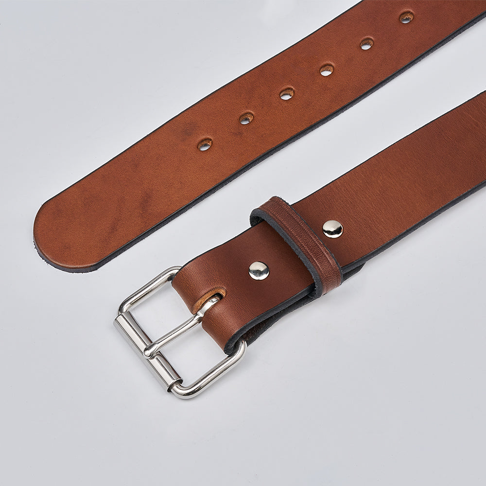 The Enforcer by Hanks Belts is a brown leather gun belt with a silver buckle and metal studs, shown flat on a white surface. This 1.75" CCW belt has multiple adjustment holes along its length for concealed carry use.