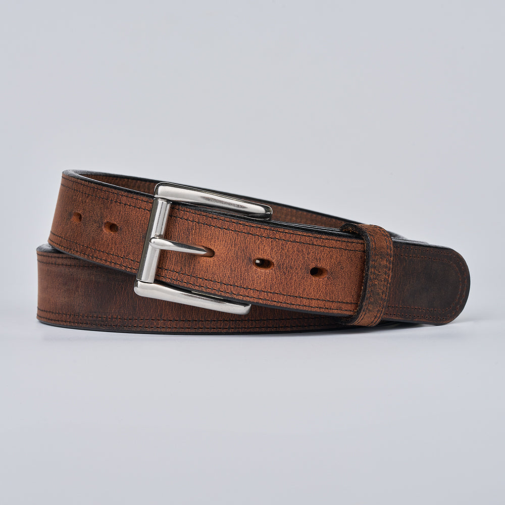 Brown leather belt with silver buckle on a light gray background