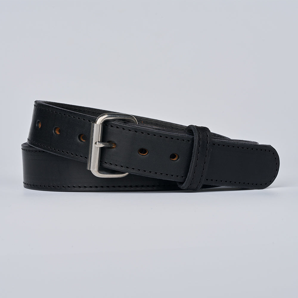 The Xtreme - 1.5" by Hanks Belts is a black leather gun belt with a silver buckle, neatly rolled and displayed on a plain light gray background.