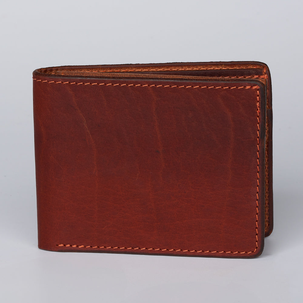 The Powell Bison Bifold with ID Window Fold Over by Hanks Belts, crafted in brown Bison leather with visible stitching, is shown closed and upright against a plain light gray background.