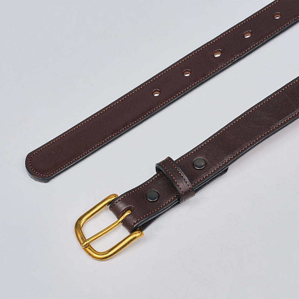 The Addyson - 1" by Hanks Belts, made from English Bridle Full-Grain Leather, is displayed flat on a light gray surface. It features a brass buckle, multiple strap holes, and two black rivets by the buckle.