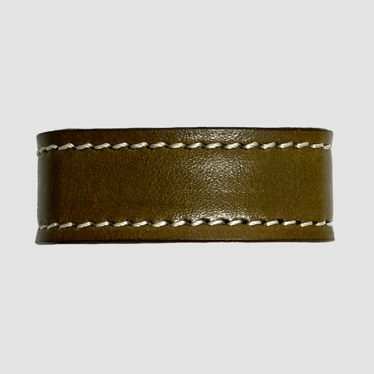 A close-up of the Hanks Belts 1.5" Stitched #10 Keeper, crafted from brown vegetable tanned leather with white edge stitching, ideal for dress belts, displayed against a plain gray background.